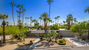A modern building with a flat roof, surrounded by palm trees and landscaped gardens. - Luxury Palm Springs Estate 3Bedroom House & 3 Casitas, Salt Water Pool & HotTub (Palm Springs)