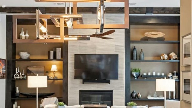 A modern living room with a fireplace, a large flat-screen TV, and a dining area with a wooden table and chairs. - Luxe Townhome | 4bd 5ba  Elevator | 1 mile from DT (Austin)