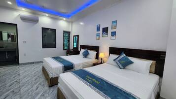 A hotel room with two beds, a bathroom, and a view of the sea.