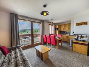 A modern apartment with a dining area, kitchen, and a balcony with a scenic view. - Apartment with wellness area in Les Saisies (Les Saisies)