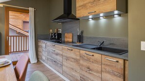Eine moderne Küche mit Holzausziehtüren, einem schwarzen Spülbecken und einem eingebauten Herd.
