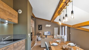 Eine moderne Küche mit Holzausbau, einem eingebauten Herd und einem großen Esstisch, gedeckt für sechs Personen.