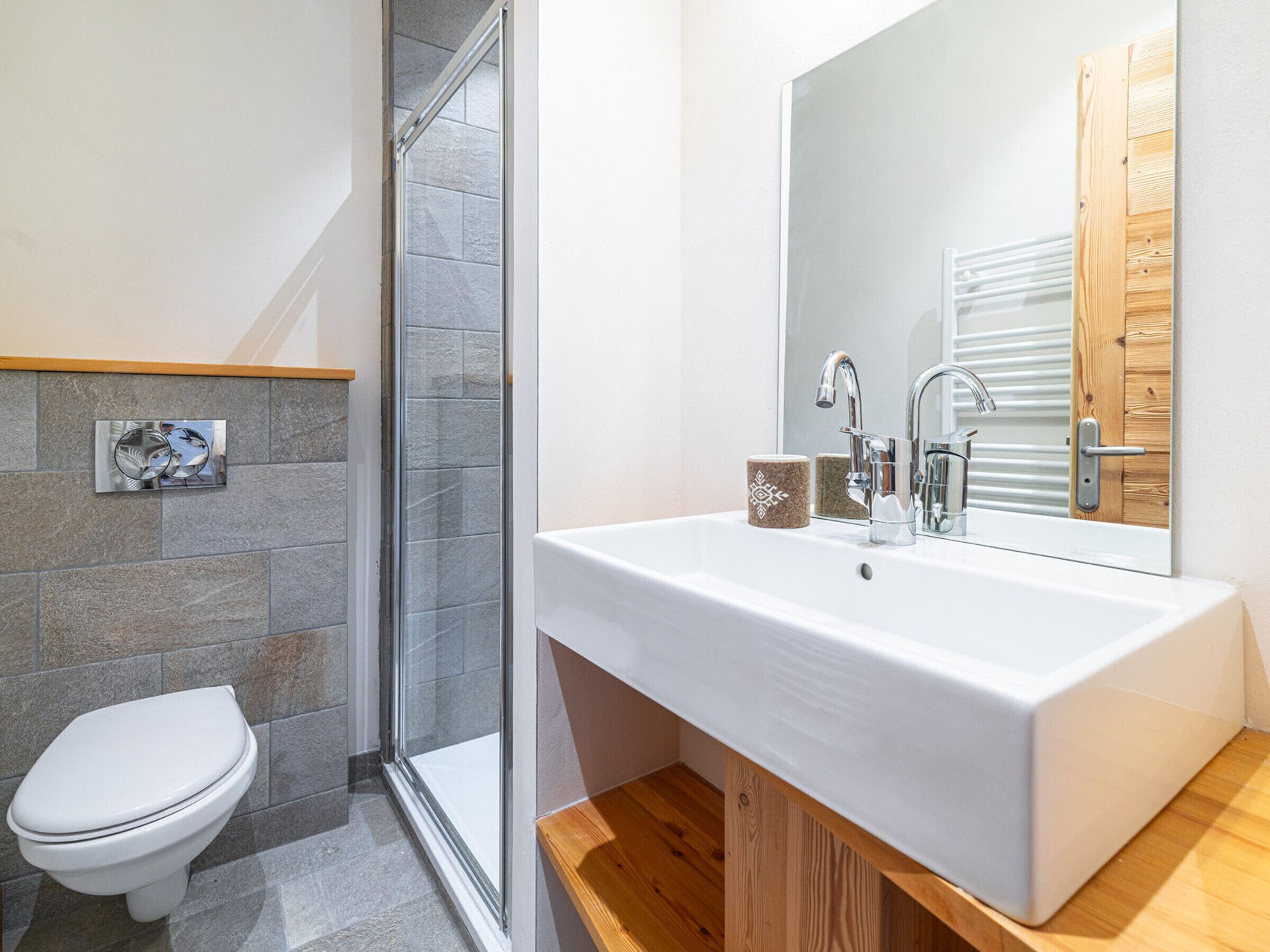 Un baño moderno con ducha, inodoro y lavamanos.