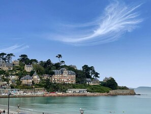 A coastal town with historic buildings, a marina, and a beach.