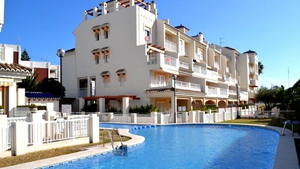 A multi-story hotel with a swimming pool, balconies, and a clear sky. - Penthouse Kalymnos (Platja de L'arenal)