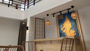 Ett modernt hotellrum med högt tak, ett takfönster och en stor karta på väggen.