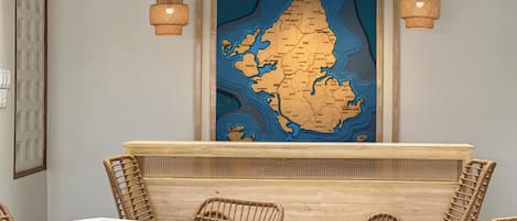 Un interno ristorante con mobili in vimini, un bancone in legno e una mappa di Siargao appesa al muro.