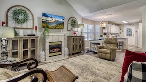 A spacious living room with a fireplace, a dining area, and a kitchen. - Convenient to Dollywood-Dinner Shows Two Bedroom Two Bathroom- Internet Access (Pigeon Forge)