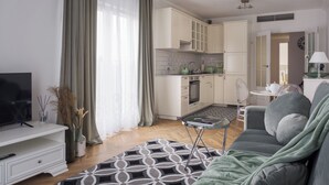 A modern living room with a sofa, a TV, and a dining area.