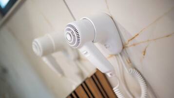 Ein an der Wand befestigter Haartrockner mit aufgewickeltem Kabel.