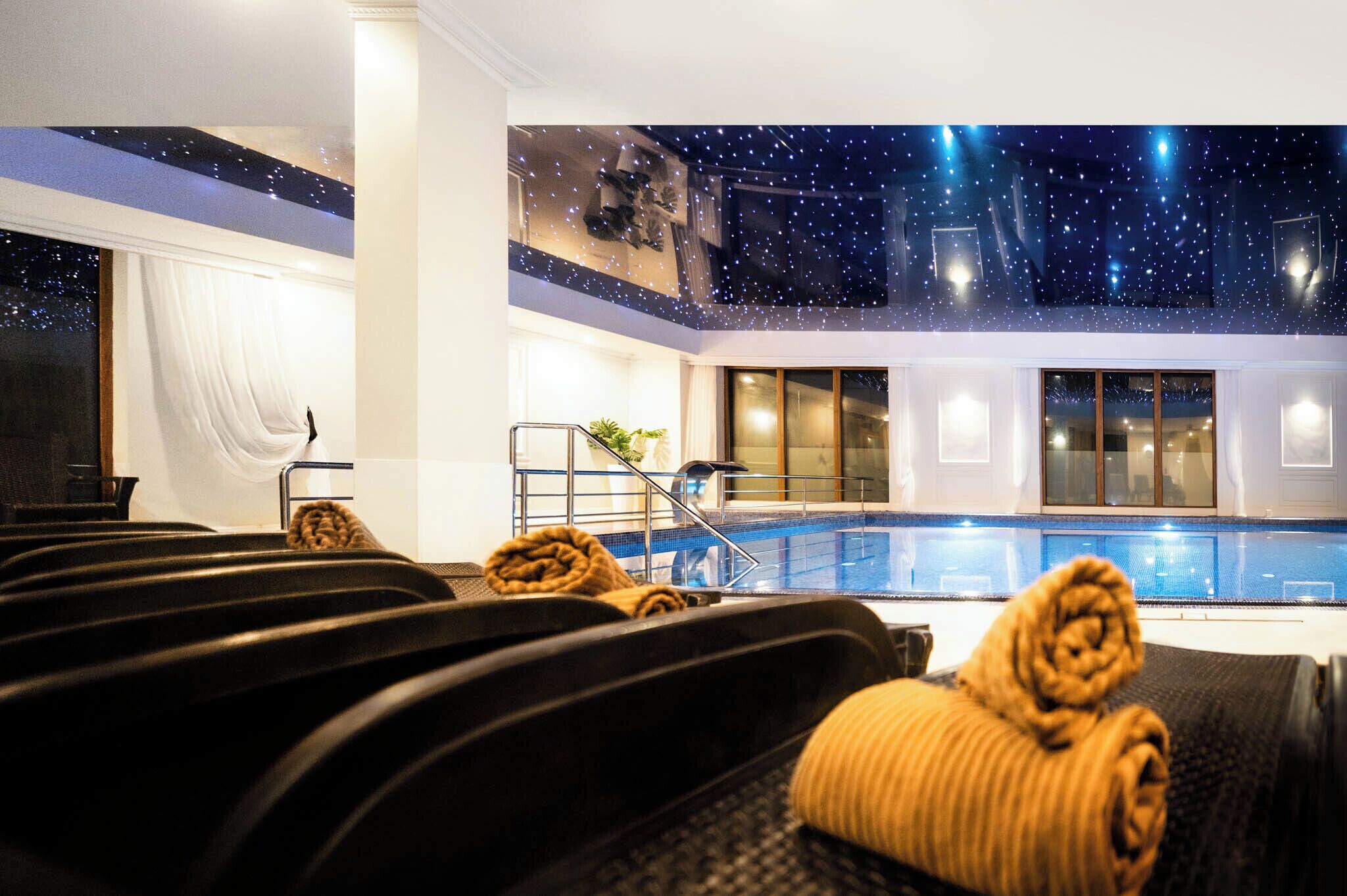 Une chambre d’hôtel avec piscine, un plafond étoilé et vue sur la piscine.