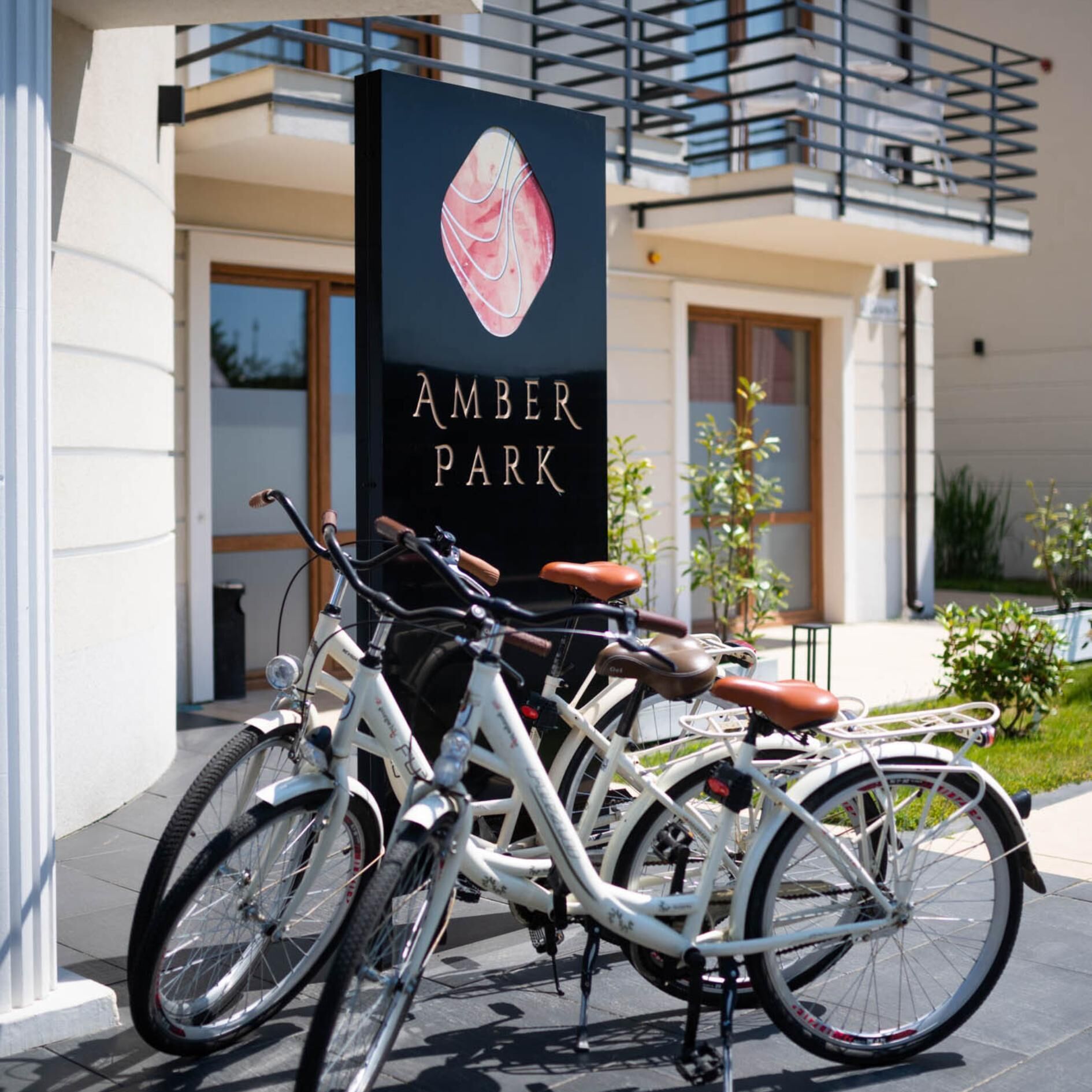 Ein Fahrrad vor einem Gebäude, an dem ein Schild mit der Aufschrift "AMBER PARK" befestigt ist.