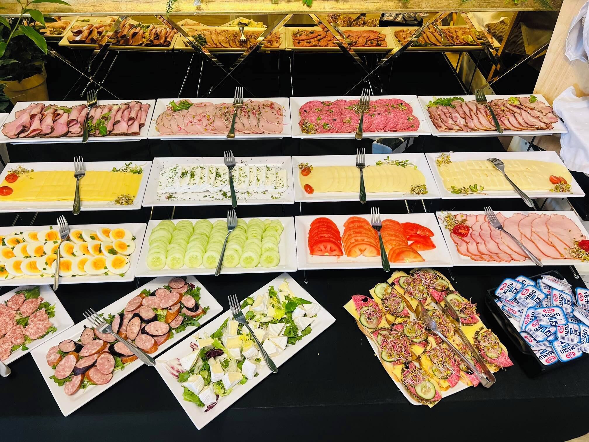 Een ontbijtbuffet met diverse gerechten, zoals vleeswaren, kazen en salades.