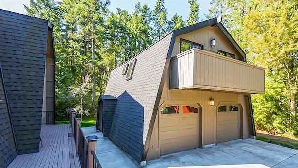 A modern two-story house with a deck, a garage, and a balcony. - Studio Loft in the Woods|Washer & Dryer|Workspace (Sequim)