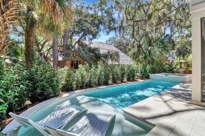 A swimming pool with lounge chairs, surrounded by lush greenery and trees. - *NEWLY BUILT HOME* 6 Bedrooms - Close to Beach - Sea Pines - Private Pool/Spa (Hilton Head Island)