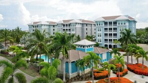 A resort with multiple buildings, palm trees, and a swimming pool.