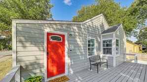 A small, single-story building with a red door and a bench on the porch. - Walk to Expo Square Pavilion: Updated Tulsa Home! (Tulsa)