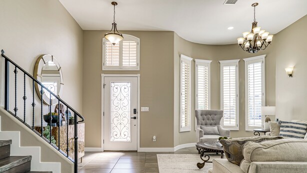 A spacious living room with a staircase, a chandelier, and a large window with shutters. - El Paso Home Near Downtown & Parks (El Paso)