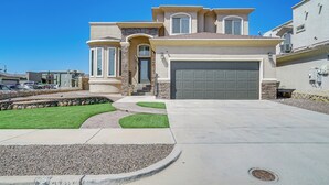 A modern two-story house with a garage, a stone facade, and a well-maintained lawn. - El Paso Home Near Downtown & Parks (El Paso)