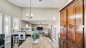 A spacious kitchen with granite countertops, wooden cabinets, and a central island with a potted plant. - El Paso Home Near Downtown & Parks (El Paso)