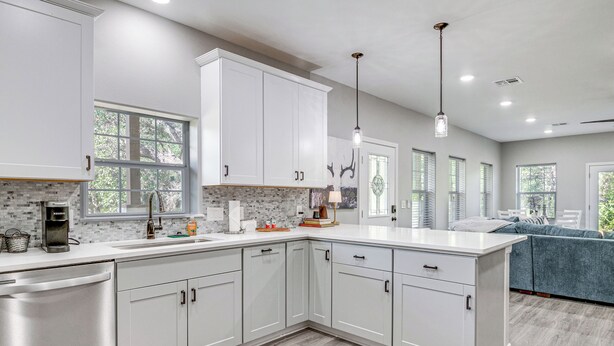 A modern kitchen with white cabinetry, a built-in dishwasher, and a large island. - Pond + Trails On-site: Washington Escape! (Washington)