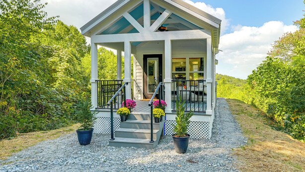 A covered porch with steps leading to a door, surrounded by potted plants and a gravel path. - Franklin Cottage: Deck w/ Blue Ridge Mtn Views! (Franklin)