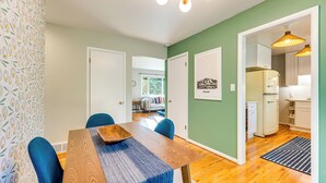 A dining area with a wooden table, blue chairs, and a patterned wallpaper. - Central Boulder Home w/ Outdoor Oasis, Walk to CU! (Boulder)
