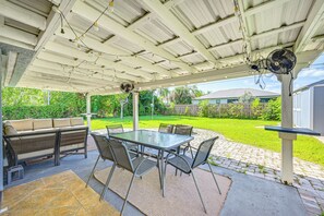 An outdoor patio with a glass table and chairs, a sofa, and a fan. - 10 Mi to Bonita Beach: Pet-friendly Home w/ Yard! (Bonita Springs)