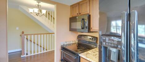 A kitchen with a stainless steel refrigerator, microwave, oven, and water dispenser.