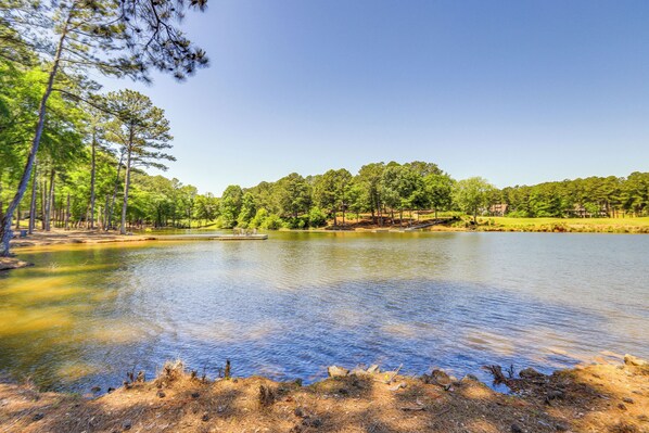 Un lac paisible, entouré d’arbres, et une zone herbeuse.