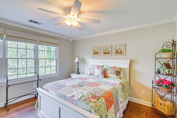 A bedroom with a bed, a ceiling fan, a window with blinds, and a nightstand with a lamp. - Upscale Home at Lake Oconee - Family Friendly! (Greensboro)