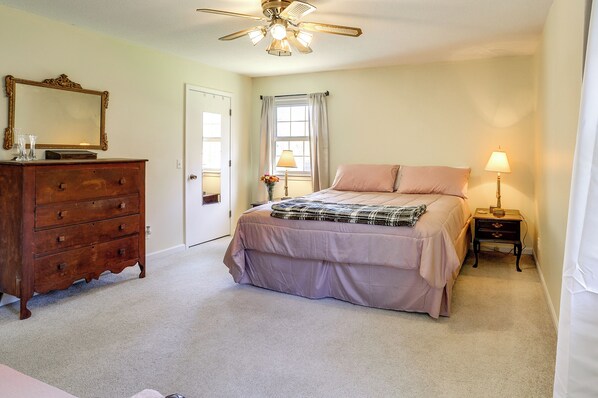 A bedroom with a bed, dresser, ceiling fan, window, and nightstand. - Charming Paris Home w/ Porch: Hunt + Unwind! (Paris)