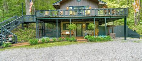 A cabin with a porch, steps, and a flag.