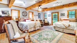 A spacious bedroom with two beds, a large window, a ceiling fan, and a wooden floor. - 'bear Acres Getaway' Cabin w/ Deck in Townsend! (Townsend)