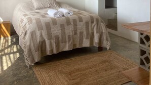 A bedroom with a bed, a hanging light fixture, and a wooden ceiling. - HOP MAR Surfea las Mejores Olas de Puemape (Puémape)