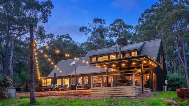 A wooden house with a porch, large windows, and string lights. - Onyx Retreat Healesville Luxury Lodge x Hot Tub (Healesville)