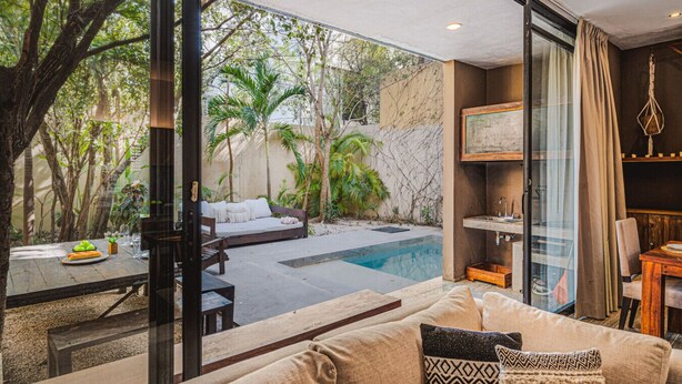 Ein modernes Wohnzimmer mit Glaswand, Pool und Essbereich.
