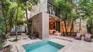 Ein modernes Gebäude mit Pool, Außenbereich und viel Grün.