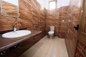 Een bad/douchecombinatie, een bidet, handdoeken, zeep