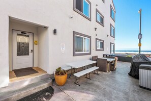 A building with a covered outdoor seating area, a door with a 'No Smoking' sign, and a view of the ocean. - Right on the Famous Mission Beach Boardwalk - Sleeps up to 10 - Best location in Mission Beach (San Diego)