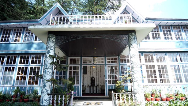 A two-story building with a balcony, large windows, and a central entrance with steps. - The Edgeworth (Shimla)