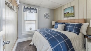 A bedroom with a bed, a window with blinds, a wall clock, and a painting. - 2BR Near Niagara Falls Parking + WiFi (Niagara Falls)