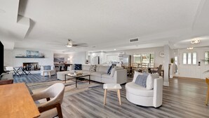 A spacious living area with a dining table, sofas, and a kitchen in the background. - Beautiful Lake View Retreat Drivable To Theme Parks 3 Bedroom Home (Haines City)
