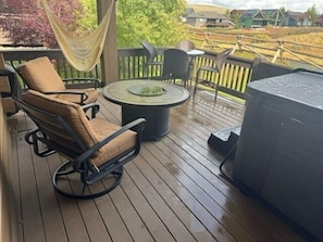 A covered outdoor patio with a round table, a cushioned chair, and a grill. - 19th Hole 3 Bedroom Cabin (Granby)