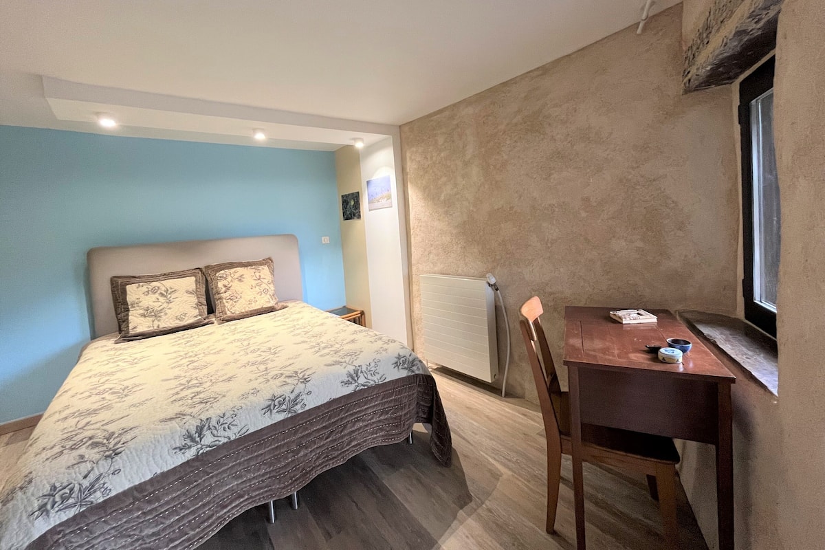 Une chambre à coucher avec un lit, une petite table et une chaise.