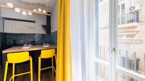 A modern kitchen with a wooden countertop, two yellow chairs, and a dining table. - Tribunali Trendy Studio by Wonderful Italy (Napoli)
