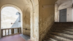 A staircase with a brick floor leading to a landing with a metal railing. - Tribunali Trendy Studio by Wonderful Italy (Napoli)