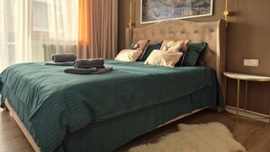 A bedroom with a large bed, a painting on the wall, and a window with curtains. - OTILIA apartment (Zell am See)