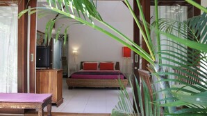 Un dormitorio con una cama, un escritorio de madera, un televisor y una lámpara roja.