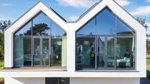 En moderne bygning med store glasvinduer og en hvid facade.